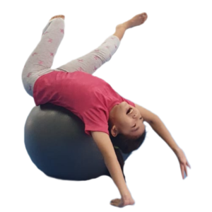 Young child rolling over a balance ball